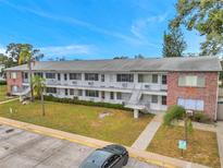 Two-story apartment building with lush green grass, parking and classic exterior stairs at 2353 Shelley St # 18, Clearwater, FL 33765