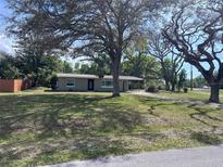 Charming single-story home with mature trees and a well-maintained lawn at 15008 Spokane Rd, Spring Hill, FL 34610
