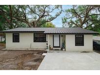 Charming single-story home featuring a metal roof, neutral paint, and minimalist landscaping at 2804 Robinson Rd, Plant City, FL 33565