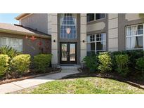Inviting home entrance with double doors, large windows, and lush landscaping at 16219 Turnbury Oak Dr, Odessa, FL 33556
