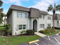 Charming condo featuring well-maintained landscaping, a palm tree and designated parking spaces at 219 S Mcmullen Booth Rd # 175, Clearwater, FL 33759