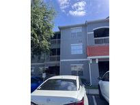 Three-story condo building with a red tile roof and gray exterior paint at 18001 Richmond Place Dr # 126, Tampa, FL 33647
