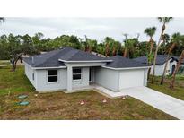 Charming single-story home featuring a neutral color scheme and well-manicured lawn with a two car garage at 4146 New Milford St, North Port, FL 34288
