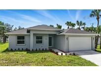 Charming single-story home with a well-manicured lawn, landscaping, and attached two car garage at 4146 New Milford St, North Port, FL 34288