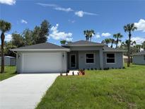 Charming single-story home with a two-car garage, fresh landscaping, and a well-manicured lawn at 4098 New Milford St, North Port, FL 34288