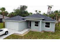 New construction home featuring gray siding, a two-car garage, and a well-manicured lawn at 4098 New Milford St, North Port, FL 34288