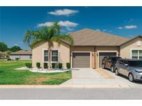 Charming home featuring a well-manicured lawn, two-car garage, and tasteful landscaping at 13475 Crest Lake Dr, Hudson, FL 34669