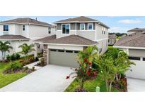Two-story home featuring an attached garage, stone accents, and landscaping at 6018 Jensen View Ave, Apollo Beach, FL 33572