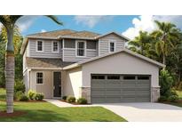 Two-story home featuring neutral colors, attached two-car garage, and nicely landscaped front yard at 6026 Jensen View Ave, Apollo Beach, FL 33572
