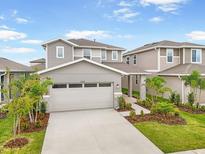 Beautiful two-story home featuring neutral tones, manicured landscaping, and an attached two-car garage at 6026 Jensen View Ave, Apollo Beach, FL 33572