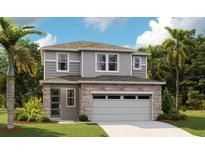 Charming two-story home with stone accents, a two-car garage, and lush landscaping at 6038 Jensen View Ave, Apollo Beach, FL 33572