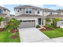 Beautiful two-story home featuring gray siding, stone accents, a gray garage door, and landscaping at 6038 Jensen View Ave, Apollo Beach, FL 33572