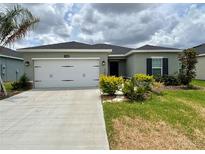 Charming single-story home featuring a two-car garage, well-maintained lawn, and fresh landscaping at 17130 11Th Ter E, Bradenton, FL 34212