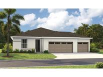 Beautiful single-Gathering home with a three-car garage, manicured lawn, and tropical landscaping at 9195 Players Dr, Weeki Wachee, FL 34613