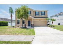 Inviting two-story home with a well-manicured lawn, a two-car garage, and elegant landscaping at 2746 Walden Woods Dr, Plant City, FL 33566