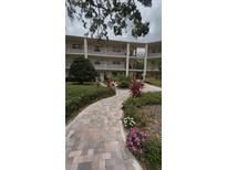 Attractive condo building boasting multiple stories, balconies and lush landscaping at 870 Virginia St # 108, Dunedin, FL 34698