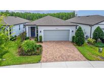 Charming single-story home featuring a brick driveway, well-manicured landscaping, and a neutral color palette at 19165 Iron Topsail Isle, Land O Lakes, FL 34638
