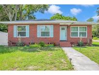 Charming single-story brick home featuring a manicured front yard, light blue shutters, and a light blue front door at 2601 Upton S St, Gulfport, FL 33711