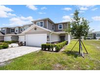 Charming two-story townhome featuring an attached two-car garage and beautifully maintained front yard landscaping at 5367 Riverwalk Preserve Dr, New Port Richey, FL 34653