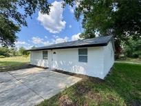 Charming single story home features a white exterior, a concrete driveway and beautiful green landscaping at 390 Hazel Cir, Punta Gorda, FL 33982