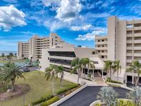 Stunning condo building featuring well-manicured lawns, vibrant palm trees, and a picturesque entrance at 6009 Sea Ranch Dr # 203, Hudson, FL 34667