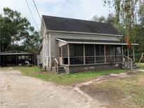 Quaint house exterior with screened porch and mature trees at 115 W Alsobrook St, Plant City, FL 33563