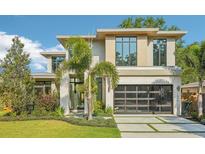 Stunning modern home featuring a sleek design, large windows, and a glass garage door at 1630 Douglas Ave, Dunedin, FL 34698