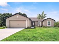 Newly constructed home with a two-car garage and well-manicured lawn at 5389 Ulysses St, Port Charlotte, FL 33981