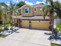 Two-story house with three car garage and landscaped yard at 10413 Hampton Meadow Way, Riverview, FL 33578