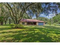 Ranch style home with stone facade, situated on a large lot with mature oak trees at 13215 Pleasant Hill Farm Rd, Thonotosassa, FL 33592