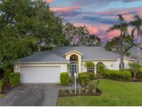 Charming single-story home with a well-maintained lawn, mature trees, and a two-car garage at 4787 Hamlets Grove Dr, Sarasota, FL 34235