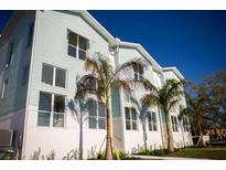 New construction shows light blue and white siding with white trim, enhanced by tropical landscaping in a sunny setting at 3850 Pompano Se Dr # 1, St Petersburg, FL 33705