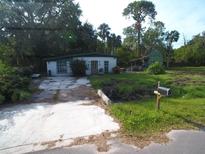 Small house with damaged exterior and overgrown yard at 6109 Adams St, Gibsonton, FL 33534