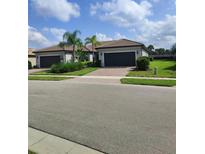 Two-story house with a two car garage and landscaped yard at 12831 Oriago St, Venice, FL 34293