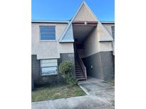Exterior view of a two-story building with stairs and landscaping at 302 E Whitehall Ct # 111, Tampa, FL 33604