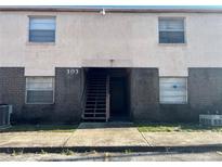 Exterior view of a light beige building with dark brown brick accents at 303 E Wellington Ct # 59, Tampa, FL 33604