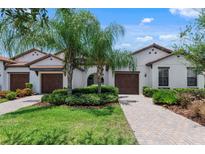 Two-story villa with attached garage and well-maintained landscaping at 17318 Holly Well Ave, Wimauma, FL 33598