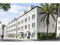 Modern three-story townhouses with white brick exterior and palm trees at 1218 E Kay St # 26, Tampa, FL 33602