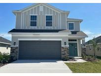 Two-story home featuring stone accents, a two-car garage, and neutral-colored siding at 7002 162Nd E Pl, Parrish, FL 34219