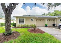 Front view of charming villa with two-car garage and well-manicured lawn at 34903 Double Eagle Ct, Zephyrhills, FL 33541