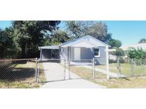 Quaint house exterior with a gated entrance and well-maintained lawn at 10008 N Jasmine Ave, Tampa, FL 33612