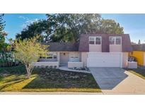 House exterior view: two-story home with a brown roof and a two-car garage at 3604 Rockaway Dr, Holiday, FL 34691
