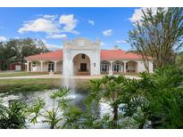 Grand estate home with red tile roof, fountain, and lush landscaping at 11623 Innfields Dr, Odessa, FL 33556