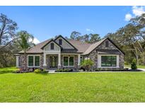 Two-story home with stone exterior and landscaping at 17059 Nokota Ave, Hudson, FL 34667