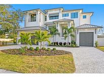 Stunning two-story home featuring lush landscaping, a circular driveway, and a three-car garage at 5032 W Longfellow Ave, Tampa, FL 33629