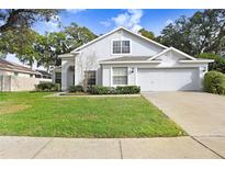 Two-story house with attached garage, manicured lawn, and mature trees at 2927 Minuteman Ln, Brandon, FL 33511