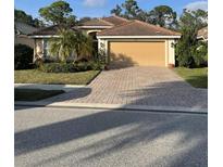 House exterior featuring a two-car garage and manicured lawn at 2156 Mesic Hammock Way, Venice, FL 34292