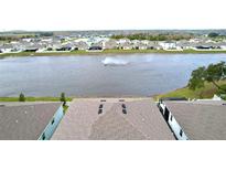 A captivating aerial view showcasing the neighborhood pond and meticulously maintained roof lines at 11946 Brighton Knoll Loop, Riverview, FL 33579