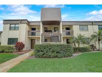 Condo building exterior featuring a two-story design and landscaping at 2400 Winding Creek Blvd # 3-202, Clearwater, FL 33761