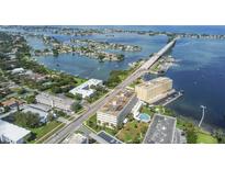 Aerial view of waterfront property with bridge, residential buildings, and boats at 100 Bluff View Dr # 607A, Belleair Bluffs, FL 33770